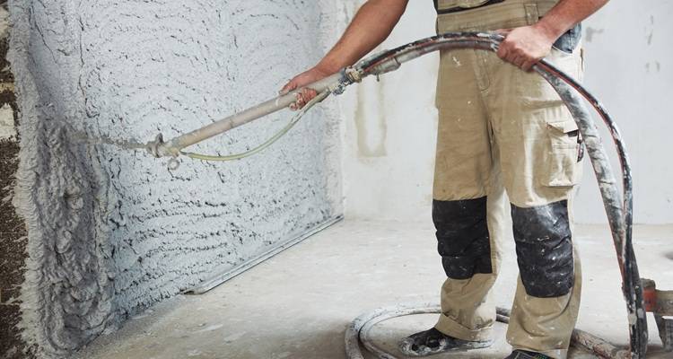 man spraying plaster