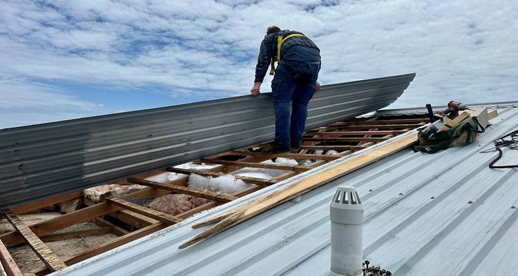 Man laying roofing sheets