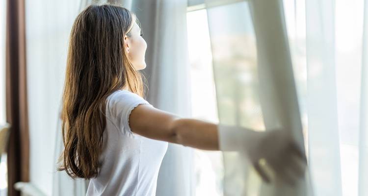 female opening curtains