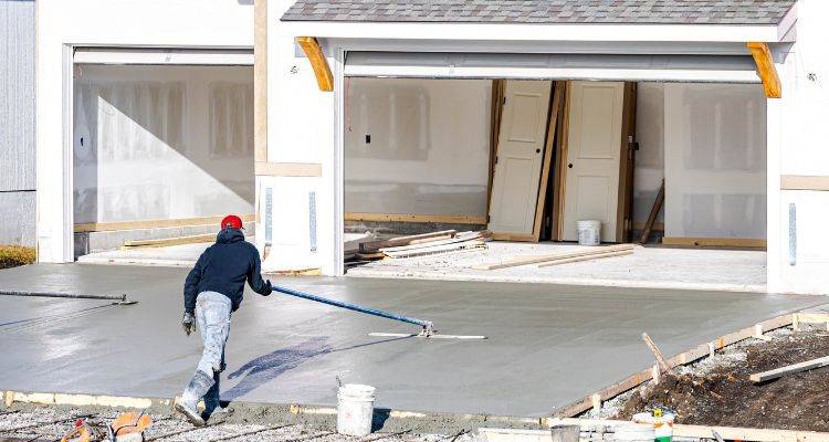 man laying concrete driveway