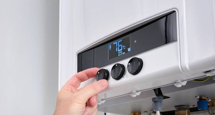 boiler installation cost guide &mdash; person using a boiler's control panel