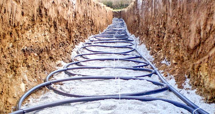 ground source heat pump cost guide &mdash; ground source heat pump being installed horizontally