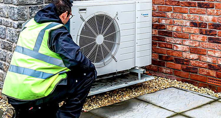 ground source heat pump cost guide &mdash; tradesperson installing heat pump
