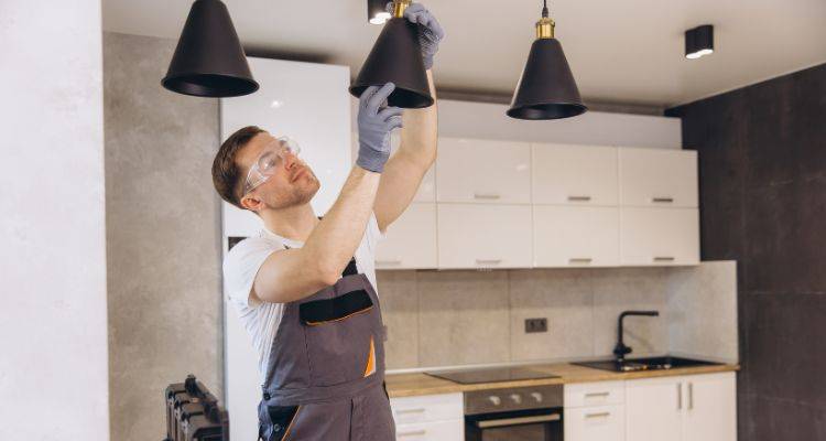 electrician installing pendant lights in a kitchen
