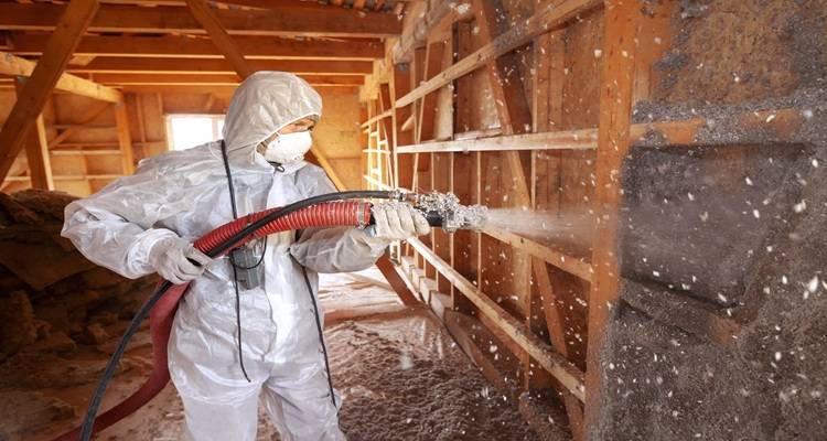 man spraying loft insulation