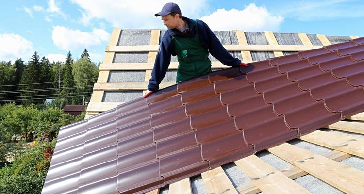 Man laying metal roof sheets
