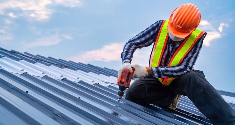 Man with drill on roof