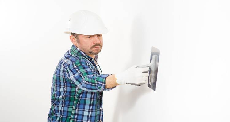 man plastering with white helmet