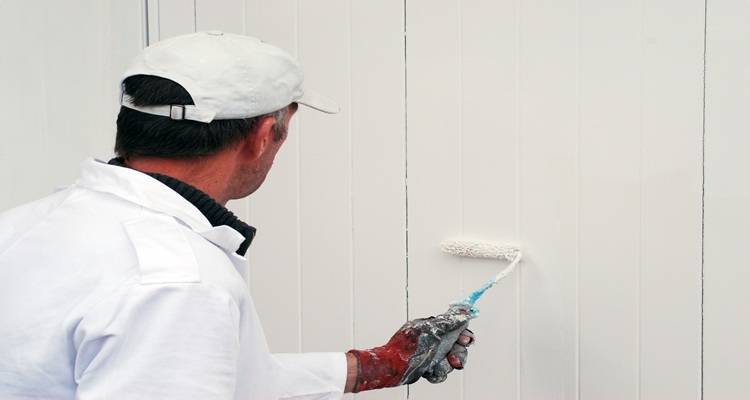 man painting garage door