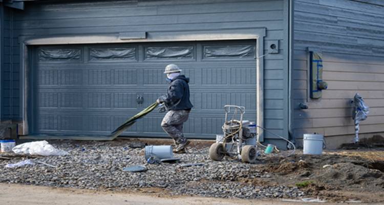 man spray painting garage
