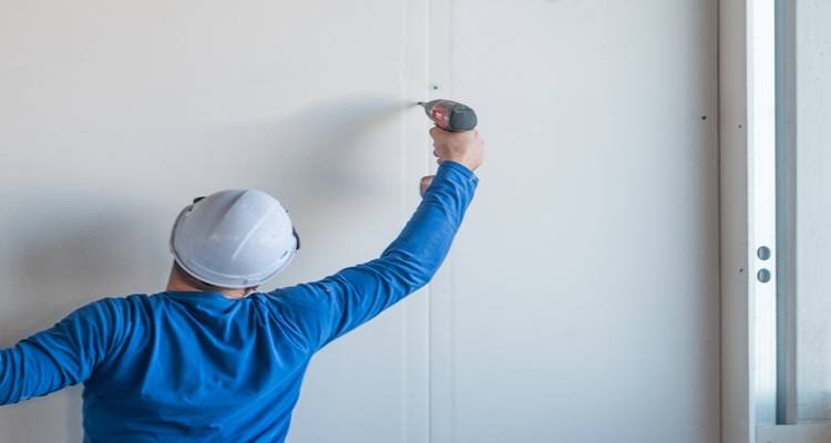 man securing plasterboard