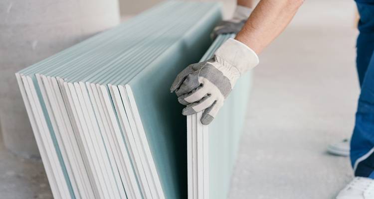 hand on stack of plasterboard