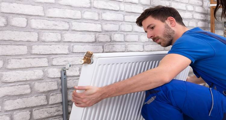 man in blue fitting radiator
