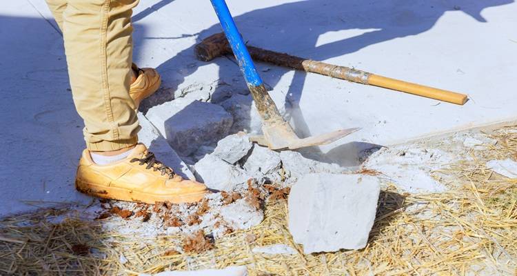 pickaxe breaking up concrete legs