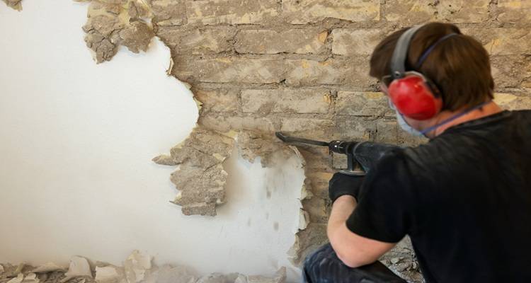 man red headphones removing plaster