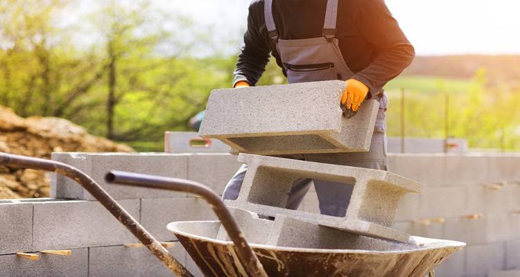man wheel barrow concrete blocks