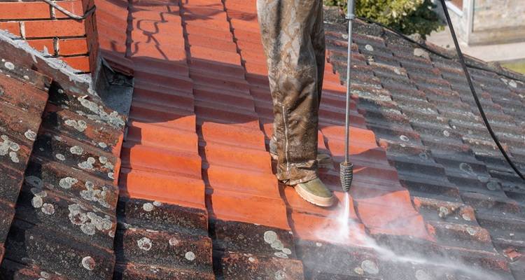 Roof being power washed
