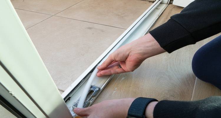 hand sealing around a door