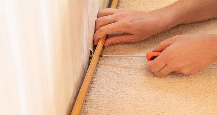 hand fixing trim to floor edges
