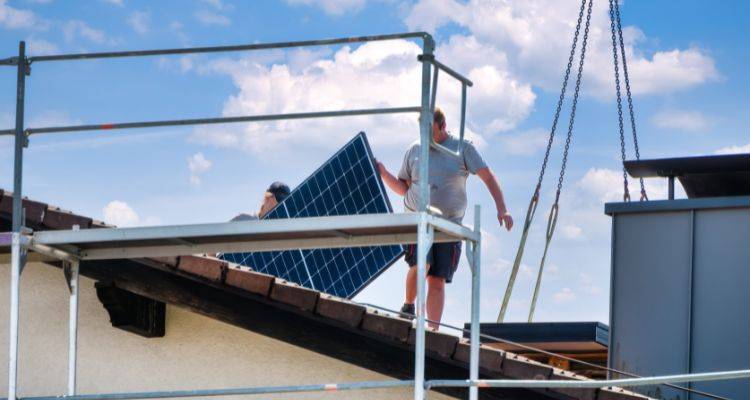 men removing solar panels from a roof