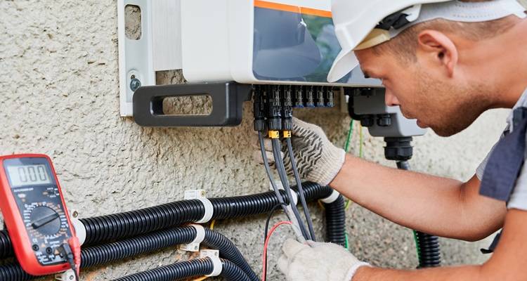 man looking at wires solar inverter