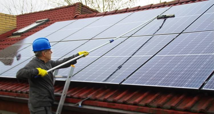 man water brush cleaning solar panels