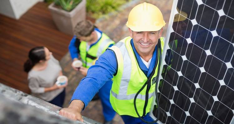 man carrying solar panel up ladder