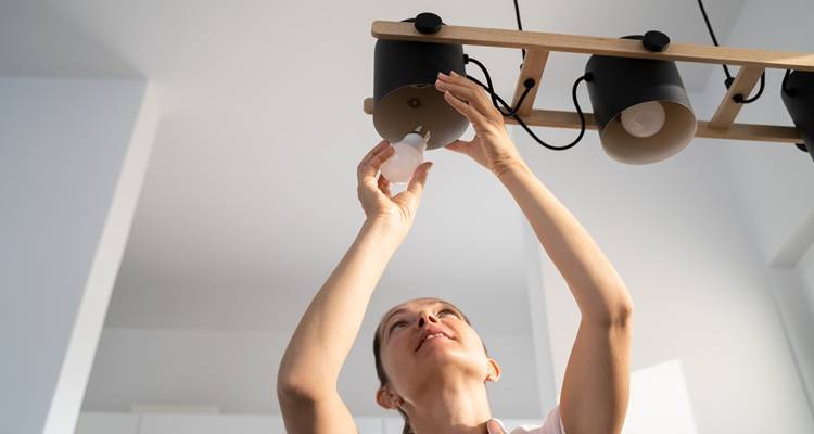 woman changing pendant light
