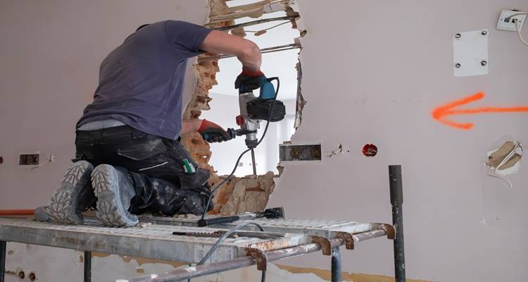 man knocking wall through