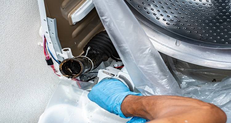 hands fixing tumble drier