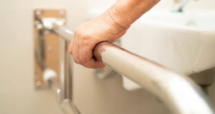 hand holding bathroom handrail