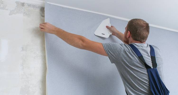 man wallpapering