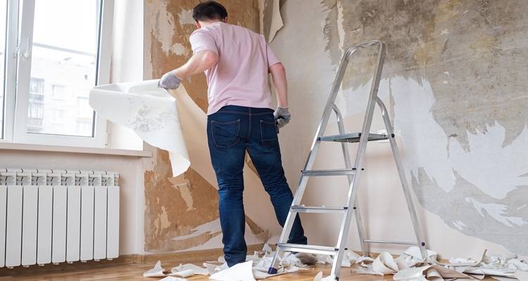 steps man stripping wallpaper