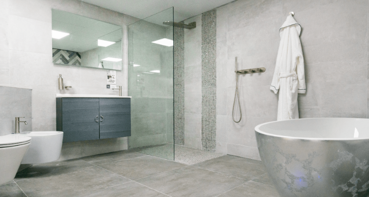 grey and white wetroom installation with a shower, toilet, and sink