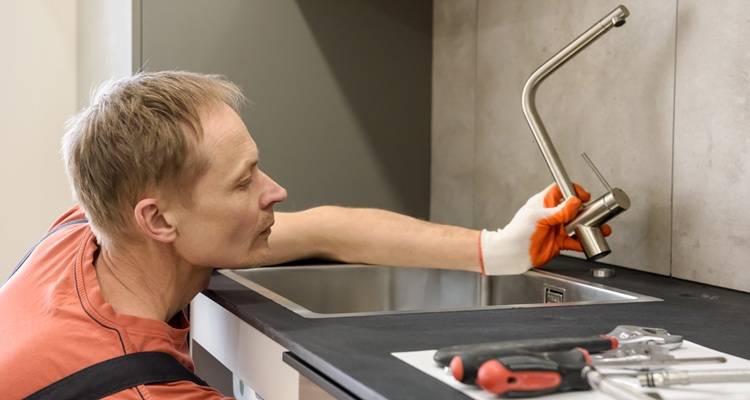plumber replacing tap orange