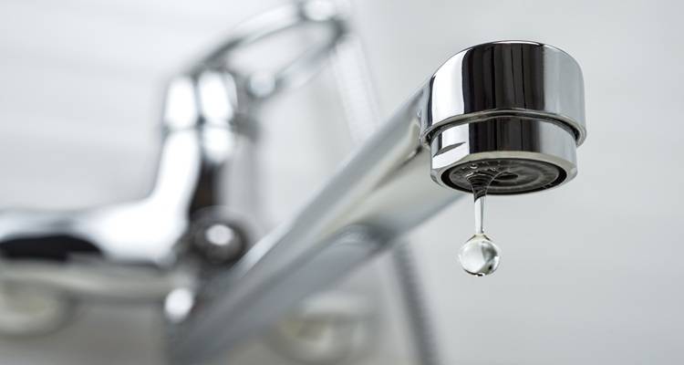 close up shiny dripping tap blurred background
