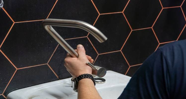 black hexagon tiles tap hand fixing it