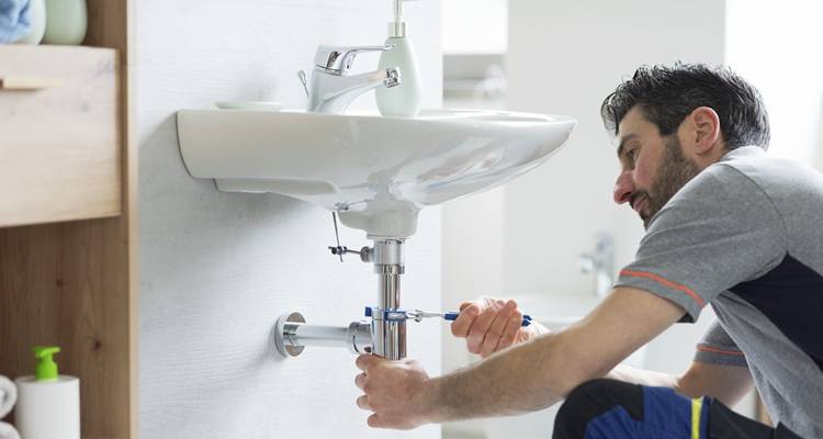 man fixing underneath sink