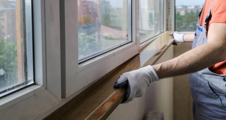 tradesperson installing a replacement window sill